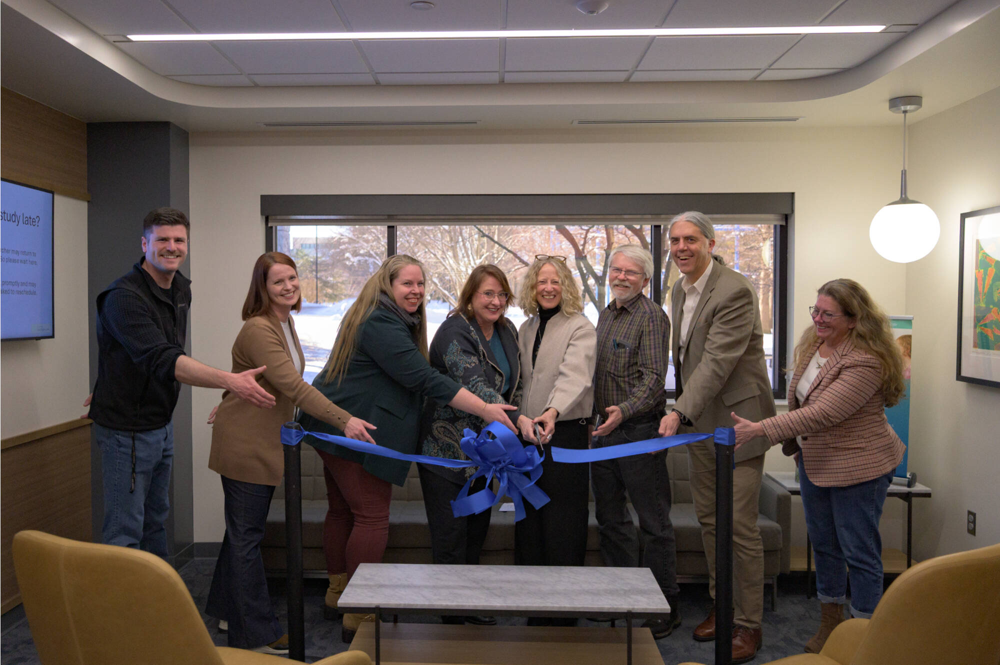 Many of the hands that helped along the lab remodel journey gather to cut the ceremonial ribbon and dedicate the new space.